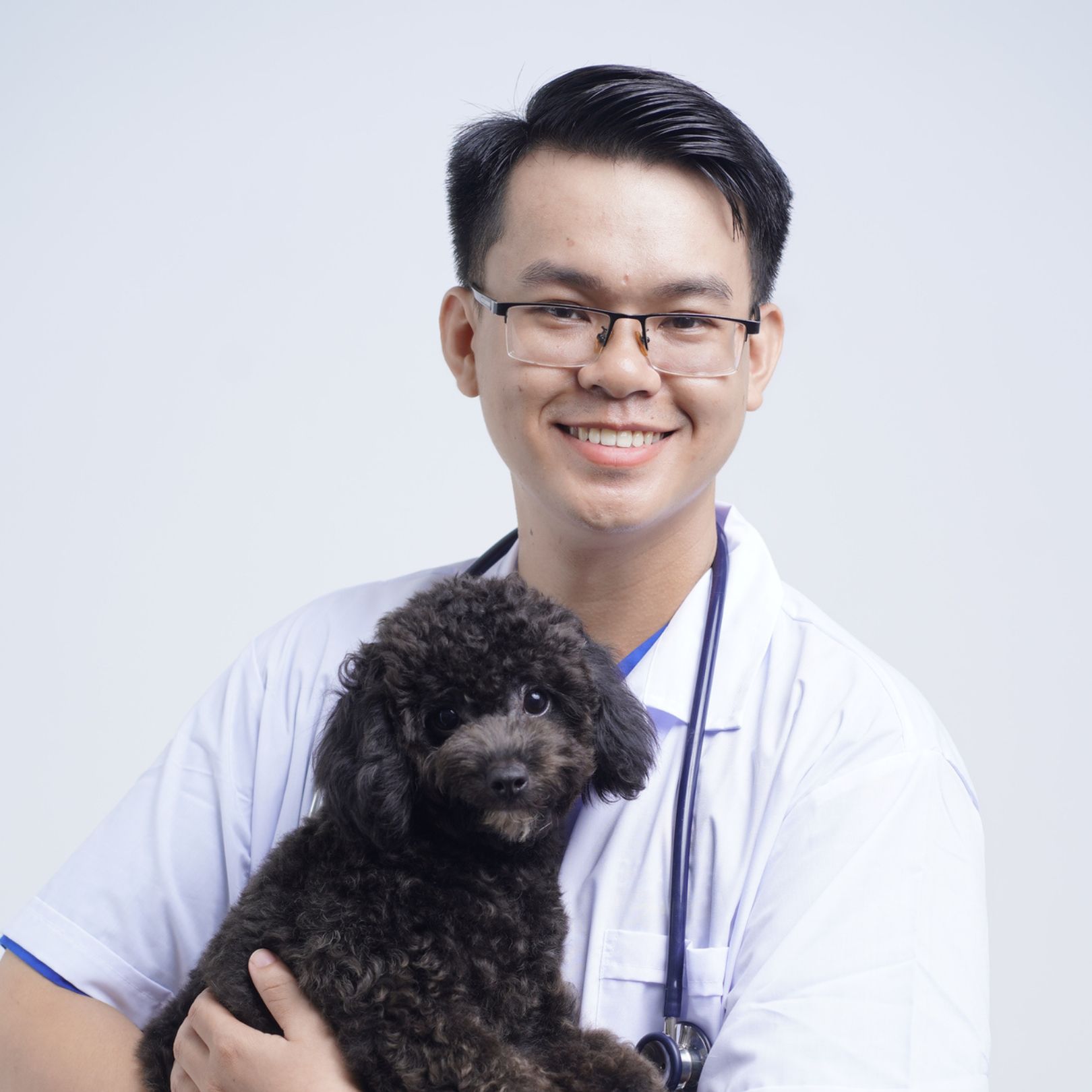 Bác sĩ thú y Lương Đức Trung — nhà sáng lập bệnh viện thú y EraVet — ôm một bé Poodle đen